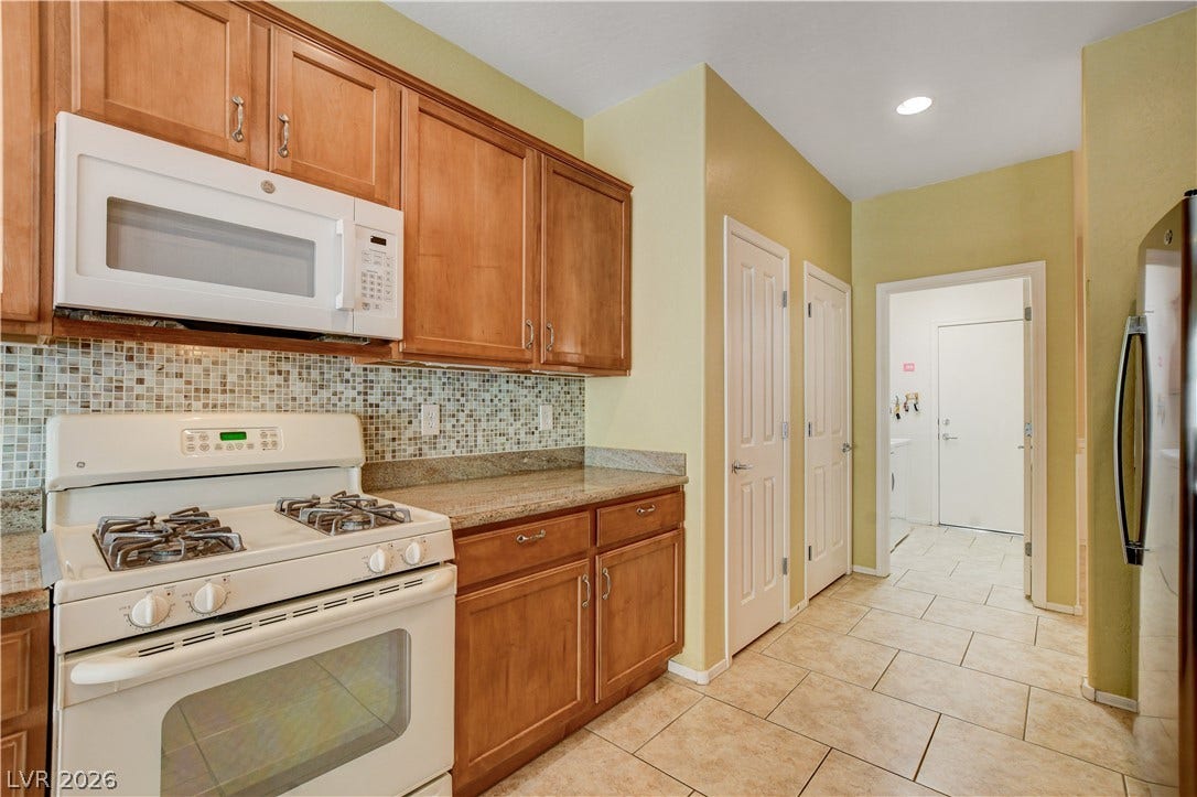 2612 Rock Pigeon Avenue, North Las Vegas, NV 89084 Warm wood cabinetry and neutral tile flooring anchor this functional workspace.
