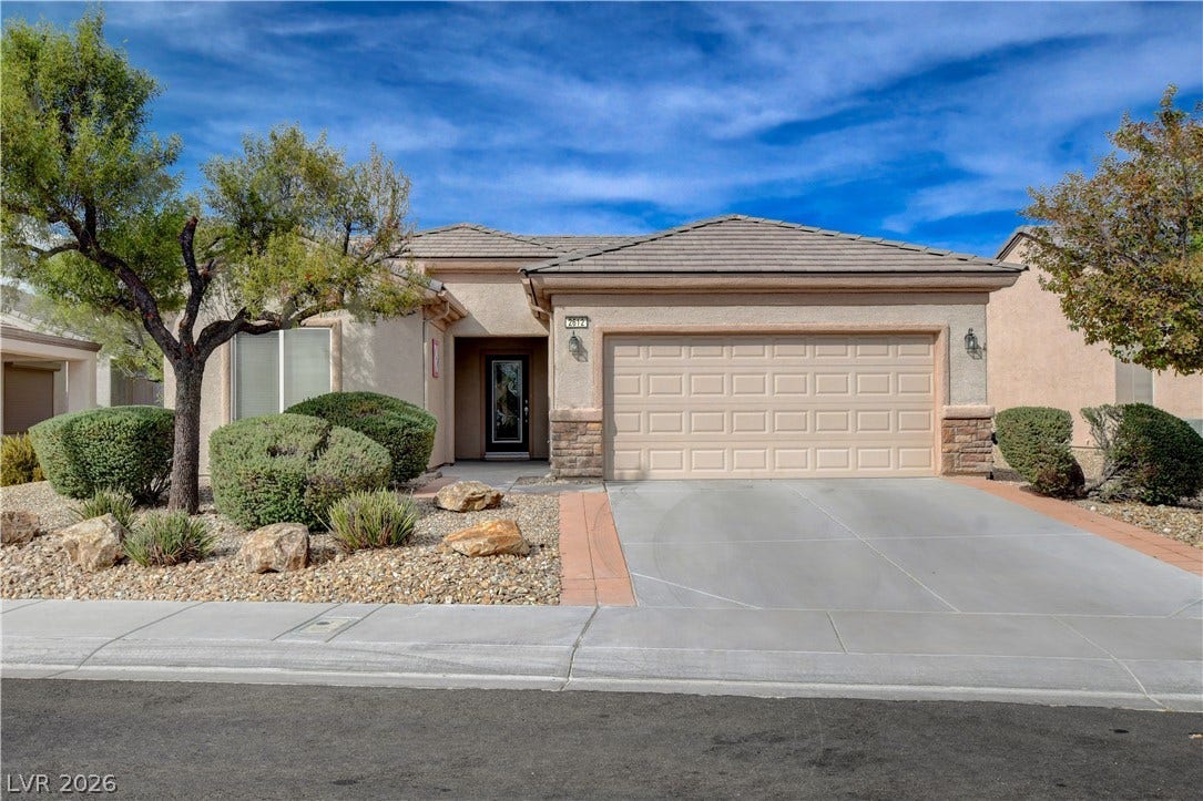 2612 Rock Pigeon Avenue, North Las Vegas, NV 89084 Desert landscaping and a paved driveway complement this classic stucco exterior.