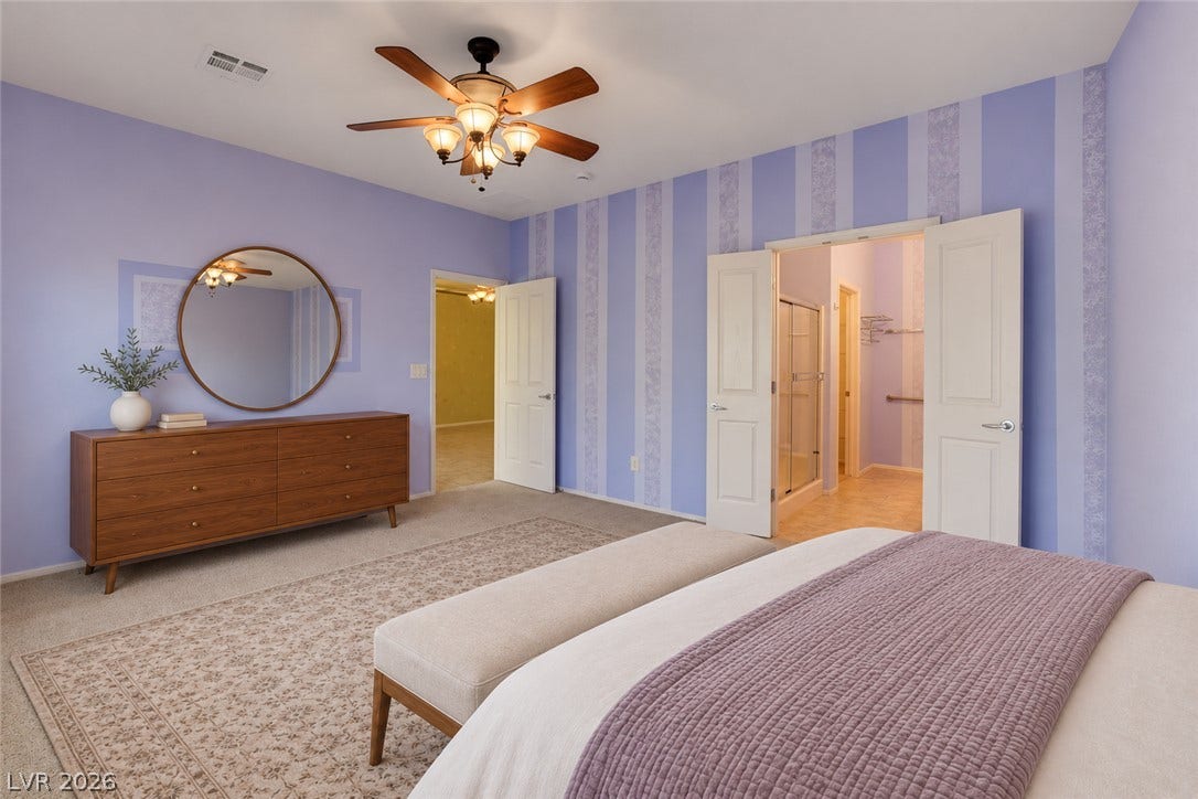 2612 Rock Pigeon Avenue, North Las Vegas, NV 89084 A spacious bedroom features direct access to an en suite bathroom and walk-in closet.