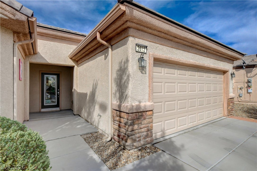 2612 Rock Pigeon Avenue, North Las Vegas, NV 89084 Textured stucco walls and stone accents frame the clean entryway and garage.
