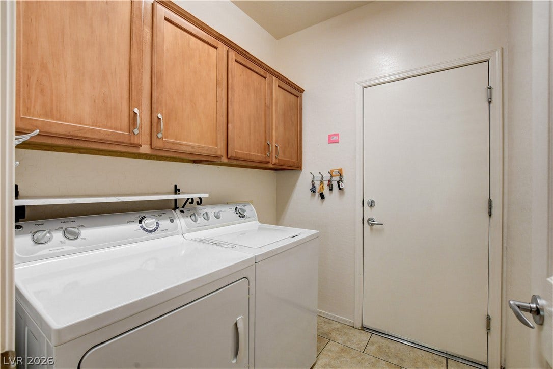 2612 Rock Pigeon Avenue, North Las Vegas, NV 89084 Ample wooden cabinetry and durable tile flooring highlight this functional laundry space.