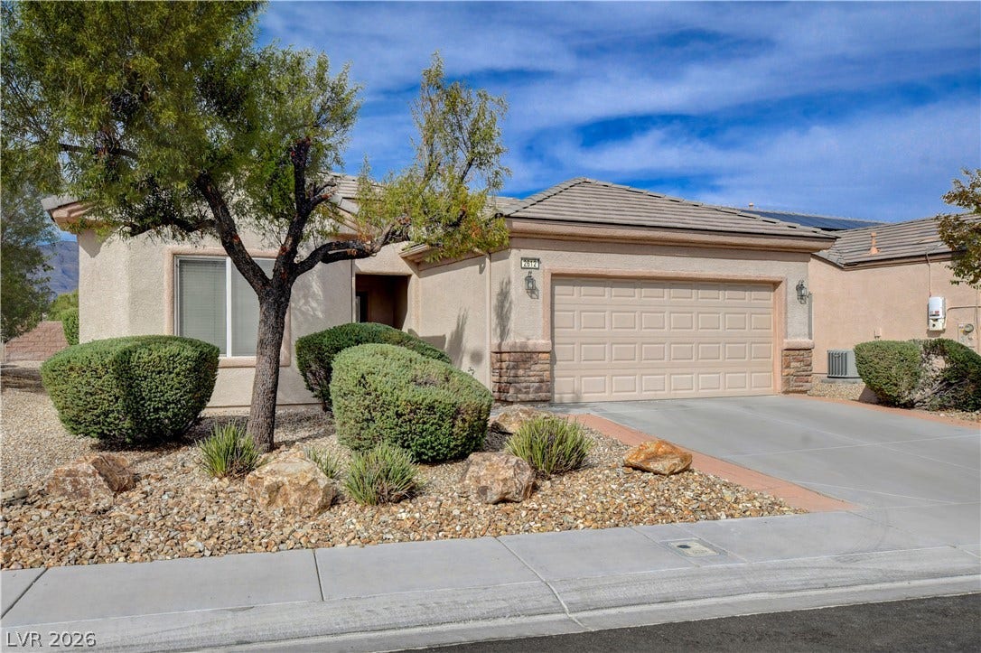 2612 Rock Pigeon Avenue, North Las Vegas, NV 89084 Desert landscaping and a paved driveway complement this classic single-story home with stucco siding.