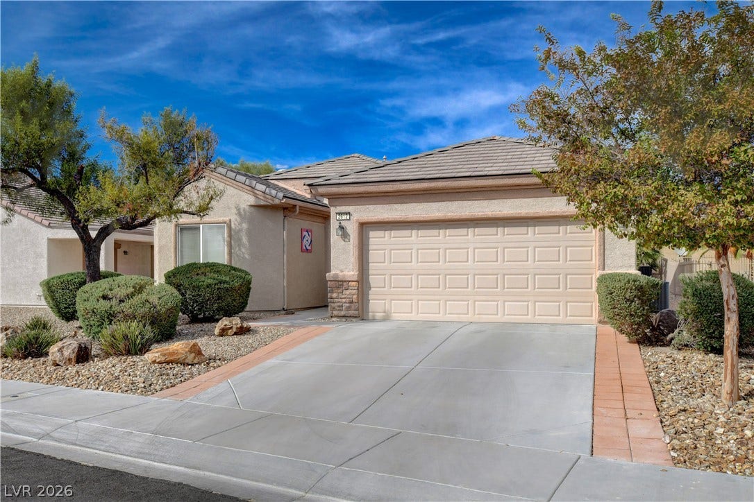2612 Rock Pigeon Avenue, North Las Vegas, NV 89084 A spacious driveway leads to the attached garage of this classic stucco home.