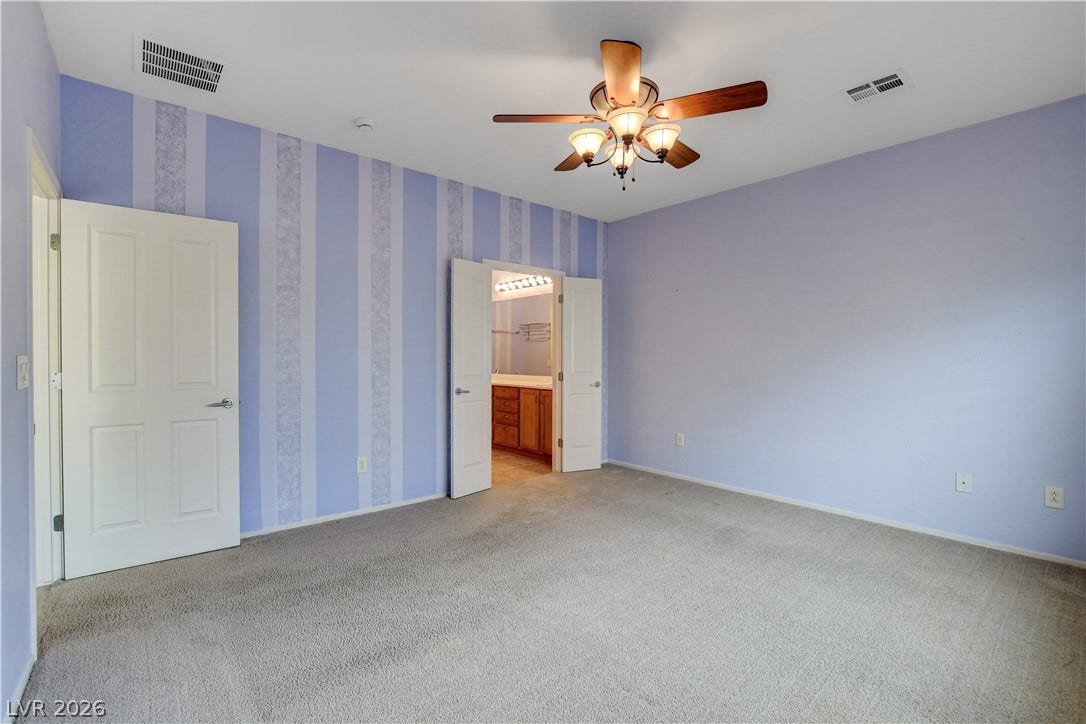 2612 Rock Pigeon Avenue, North Las Vegas, NV 89084 Double doors open from this carpeted bedroom directly into the attached bathroom.