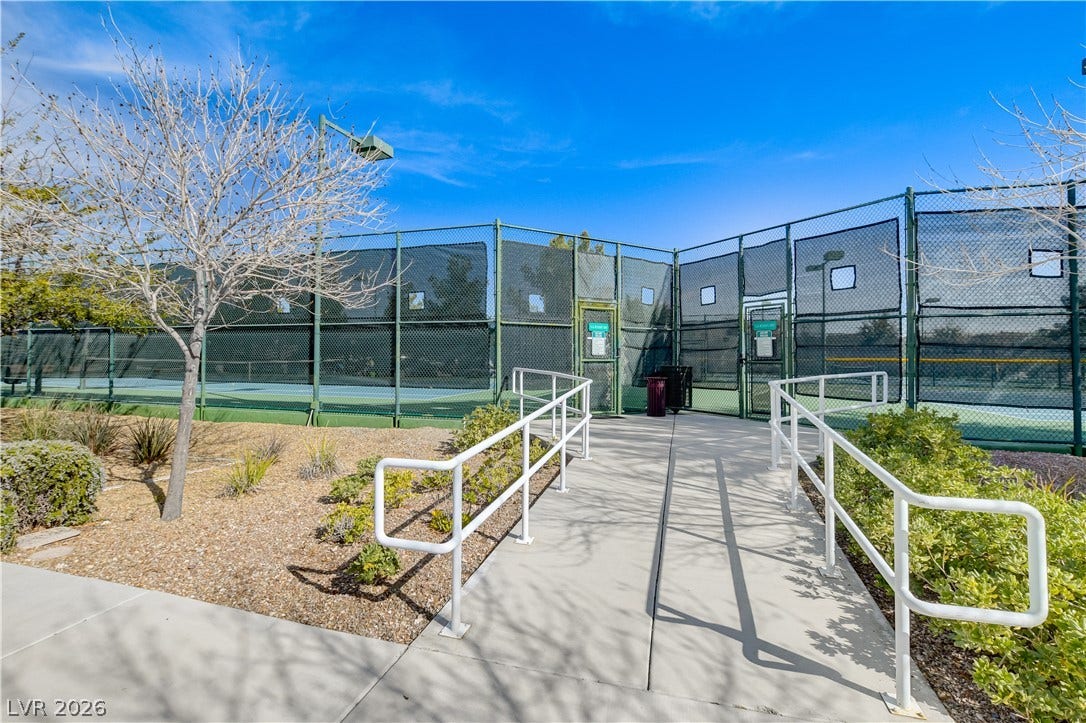 2612 Rock Pigeon Avenue, North Las Vegas, NV 89084 Concrete walkways lead directly to the fenced community sport courts under clear blue skies.