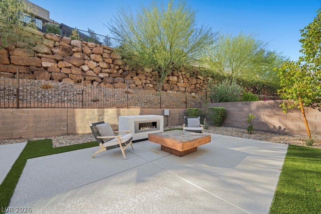 5 HIGHLAND COVE Lane, Henderson, NV 89011 This serene outdoor patio offers a chic fire pit, perfect for evening relaxation and entertaining.