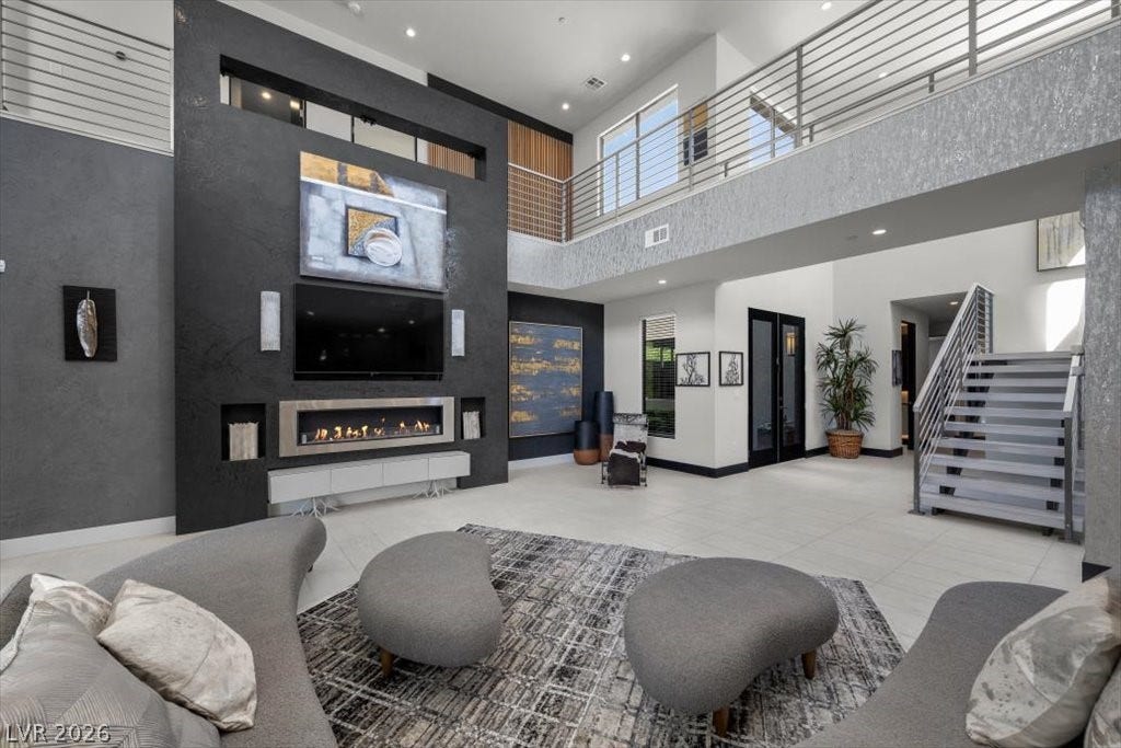 5 HIGHLAND COVE Lane, Henderson, NV 89011 This living space offers a captivating fireplace and an open concept layout with an elegant staircase.