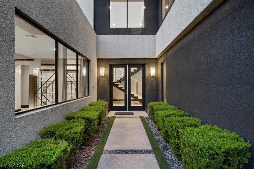 5 HIGHLAND COVE Lane, Henderson, NV 89011 The striking entrance features a clean, modern design with geometric elements and lush greenery.