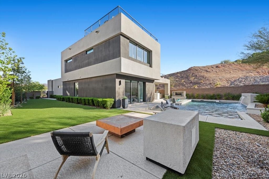 5 HIGHLAND COVE Lane, Henderson, NV 89011 Modern architecture and lush landscaping frame an inviting outdoor oasis with a refreshing pool.