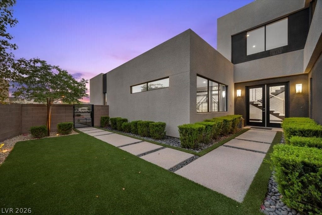 5 HIGHLAND COVE Lane, Henderson, NV 89011 This modern home features a striking facade, clean lines, and an inviting entrance with carefully manicured landscaping.