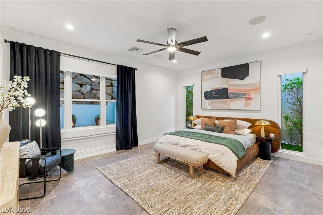 Recessed lighting illuminates this modern bedroom complete with large windows and tile flooring.