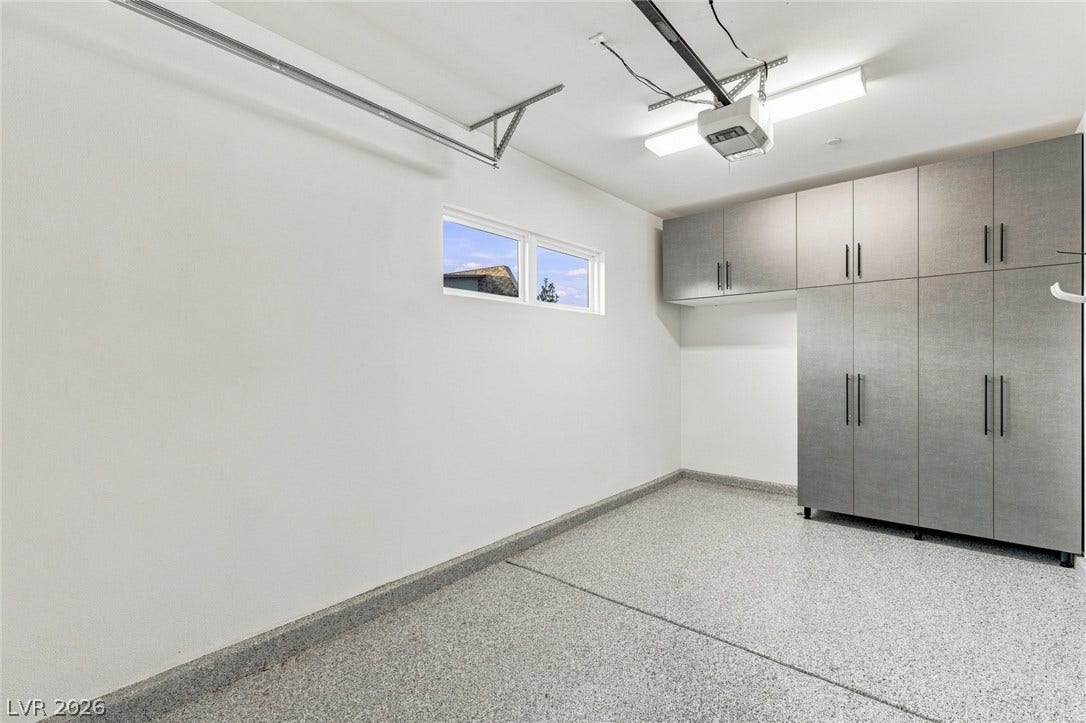 Durable epoxy flooring and extensive built-in cabinetry maximize utility in this clean garage space.