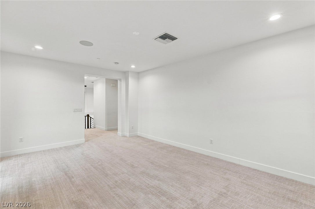 Smooth plaster walls and neutral carpeting define this clean, minimalist upper level flex space.
