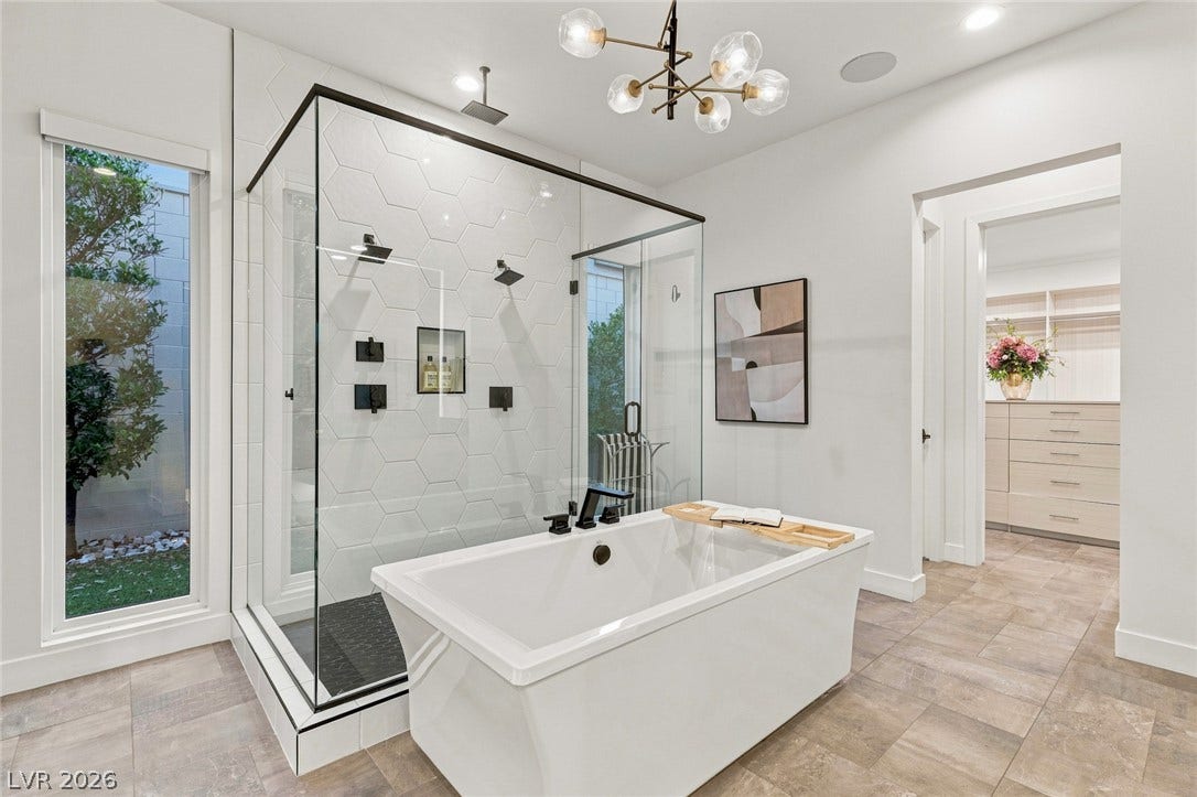 A glass-enclosed walk-in shower and freestanding tub anchor this modern bath design.