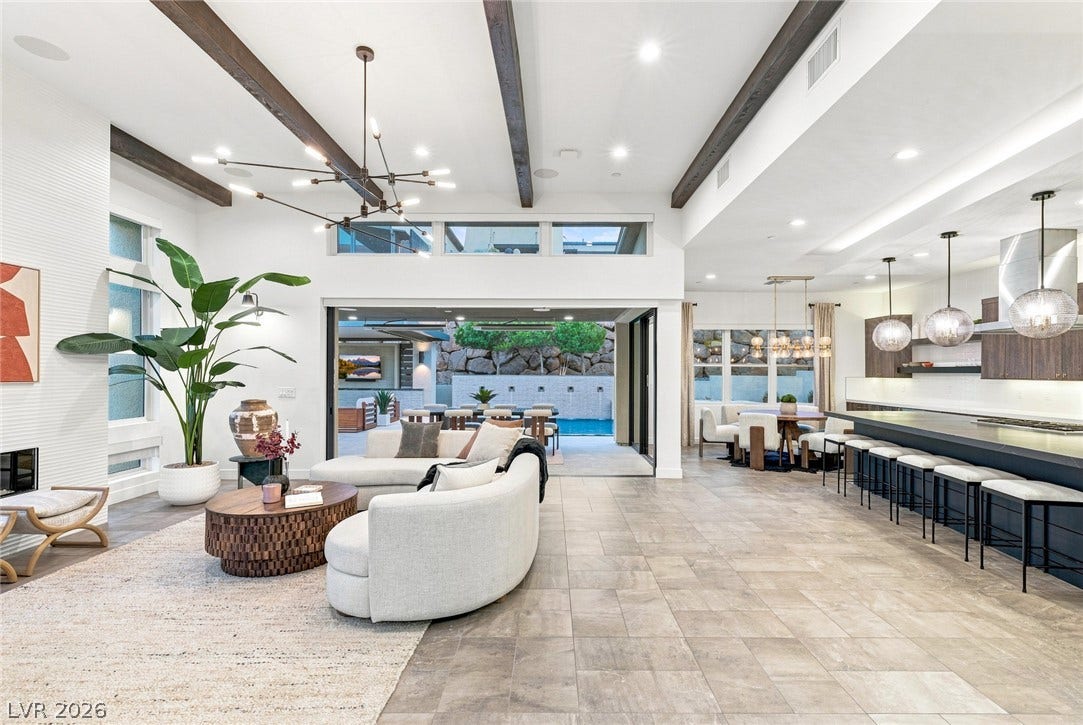 Exposed wood beams and tiled floors anchor an airy, open-concept main living space.