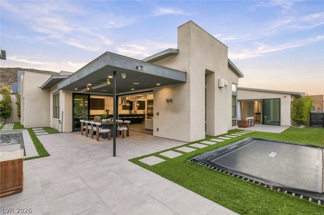 Seamless indoor-outdoor integration highlights this modern backyard patio under a protected overhang.