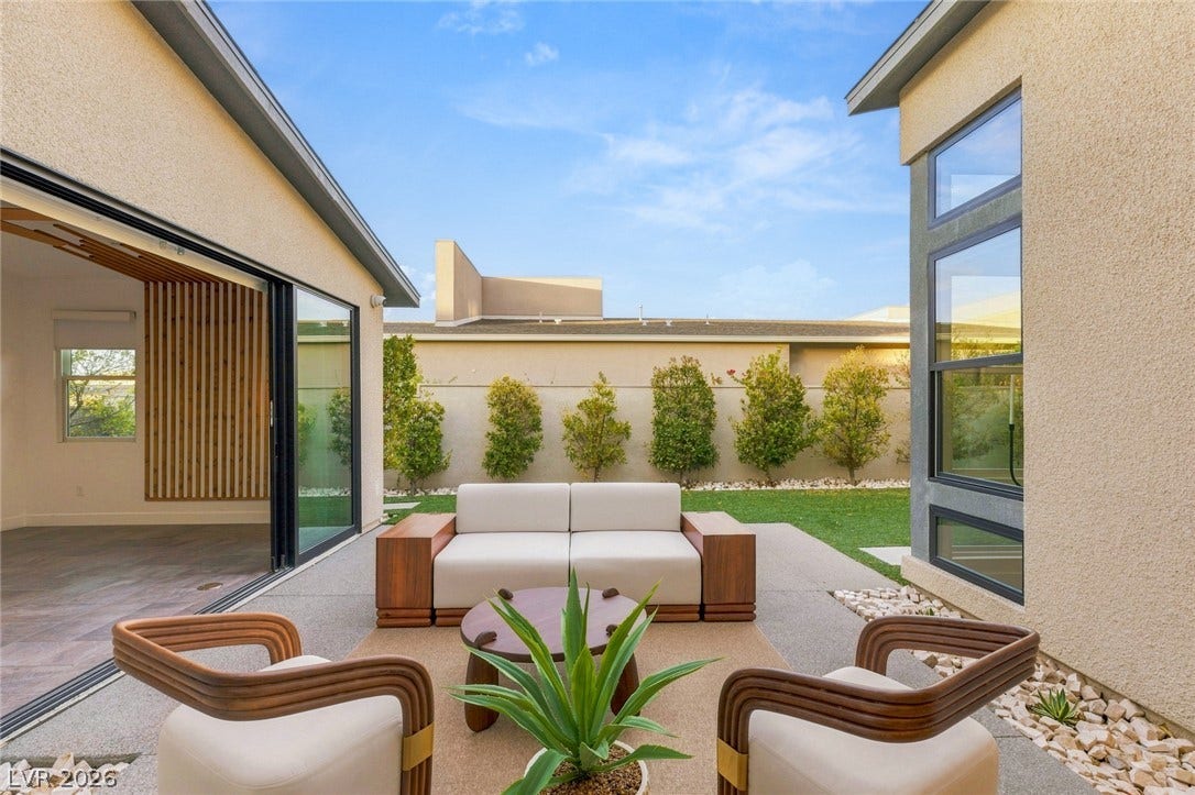 Sliding glass doors connect the interior living space to a private courtyard patio.