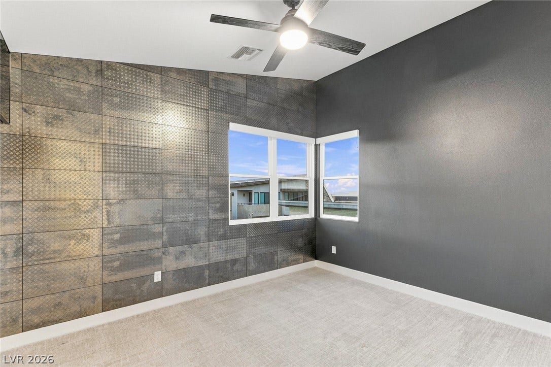 A vaulted ceiling and geometric textured walls accent this modern bedroom.
