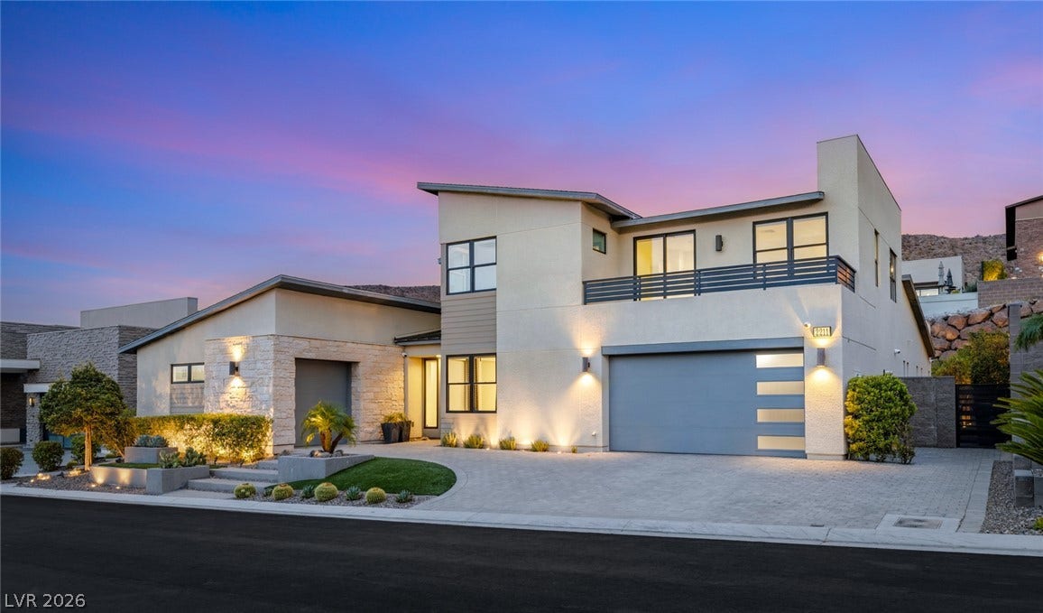 Clean lines and stone accents define this modern multi-level exterior set against a twilight sky.