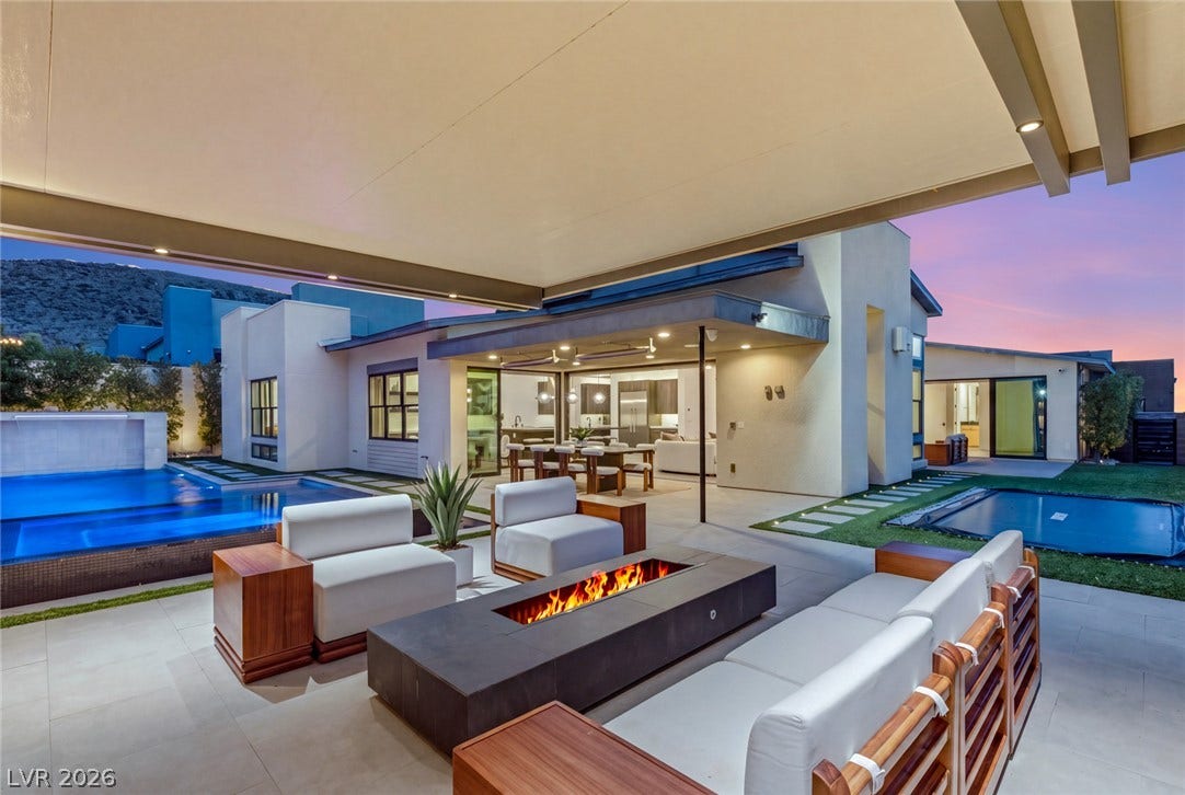 A modern covered terrace transitions seamlessly to the pool deck and outdoor fireplace lounge.