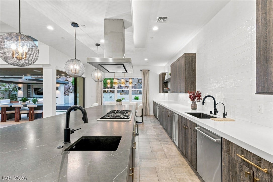 Gleaming stone countertops and sleek modern cabinetry anchor this beautifully designed culinary space.