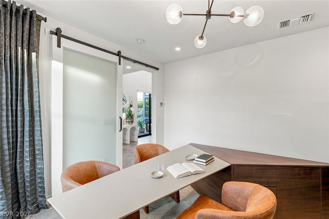 Smooth sliding glass doors enclose this private home workspace with high ceilings.