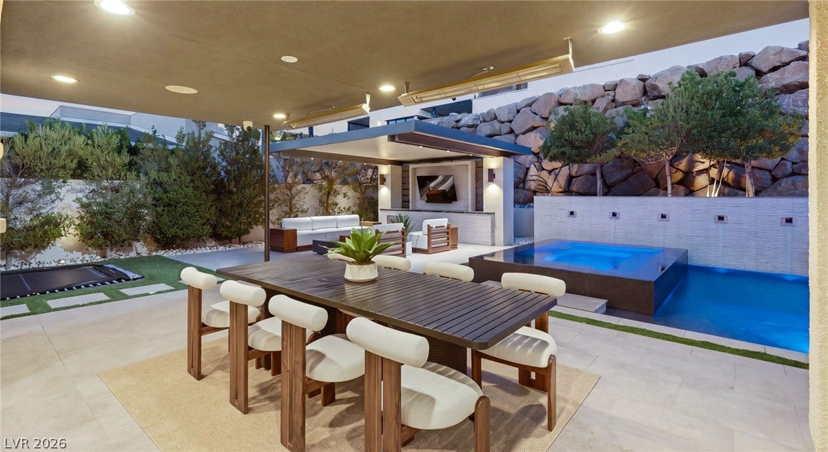 Sheltered stone tiles cover a structured outdoor dining pavilion alongside a modern plunge pool.