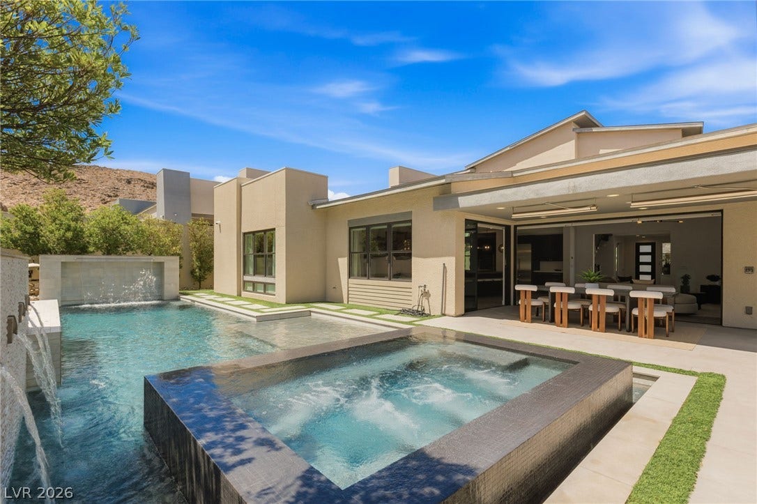 An inviting backyard oasis features a modern pool with integrated spa and covered terrace.