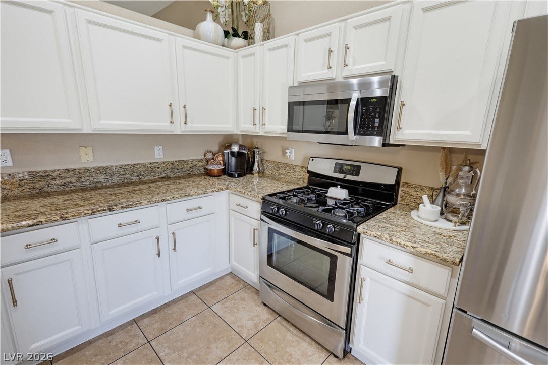 3211 Panamint Court, North Las Vegas, NV 89032 Gleaming stone countertops and stainless steel appliances anchor this bright kitchen space.