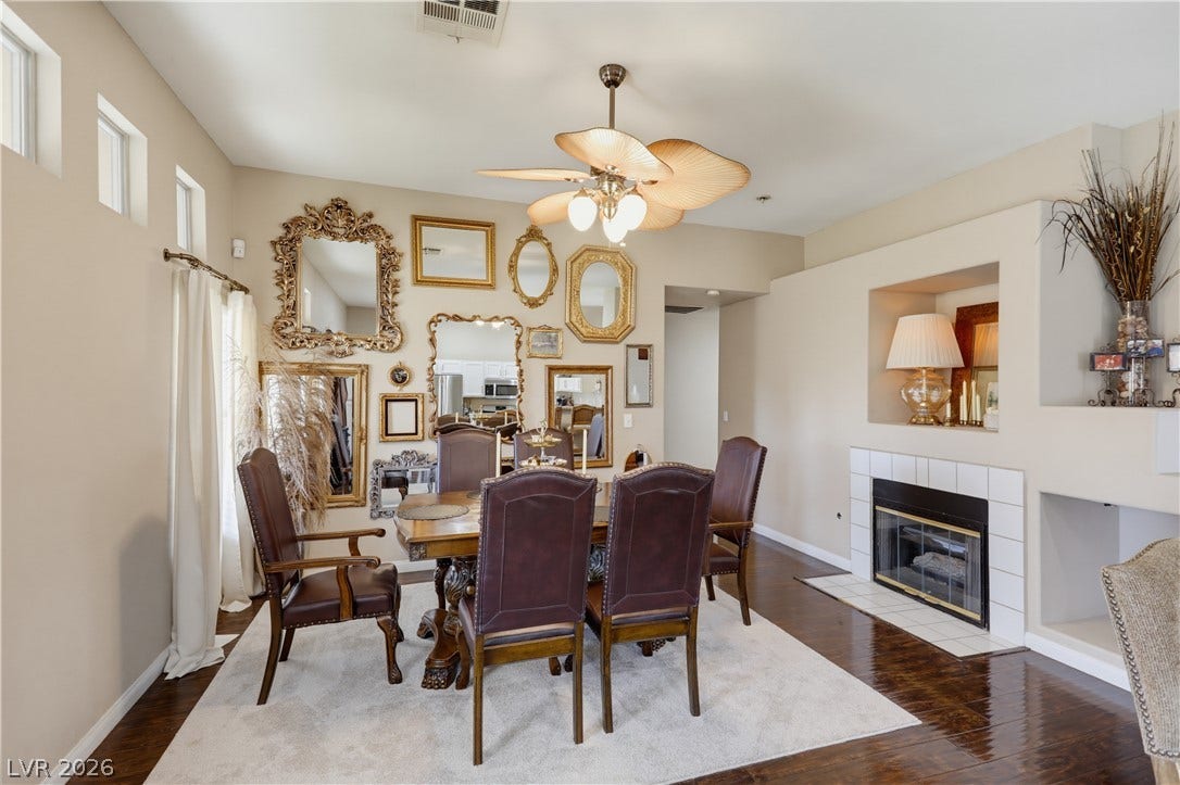 3211 Panamint Court, North Las Vegas, NV 89032 High ceilings and a tiled fireplace elevate this formal dining space with polished wood floors.