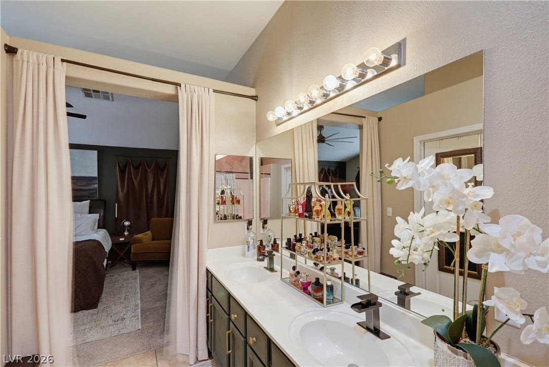 3211 Panamint Court, North Las Vegas, NV 89032 Double vanities and solid stone counters elevate this bathroom with high, vaulted ceilings.