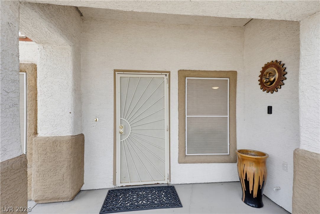 3211 Panamint Court, North Las Vegas, NV 89032 A welcoming front porch features textured stucco walls and a decorative security screen door.