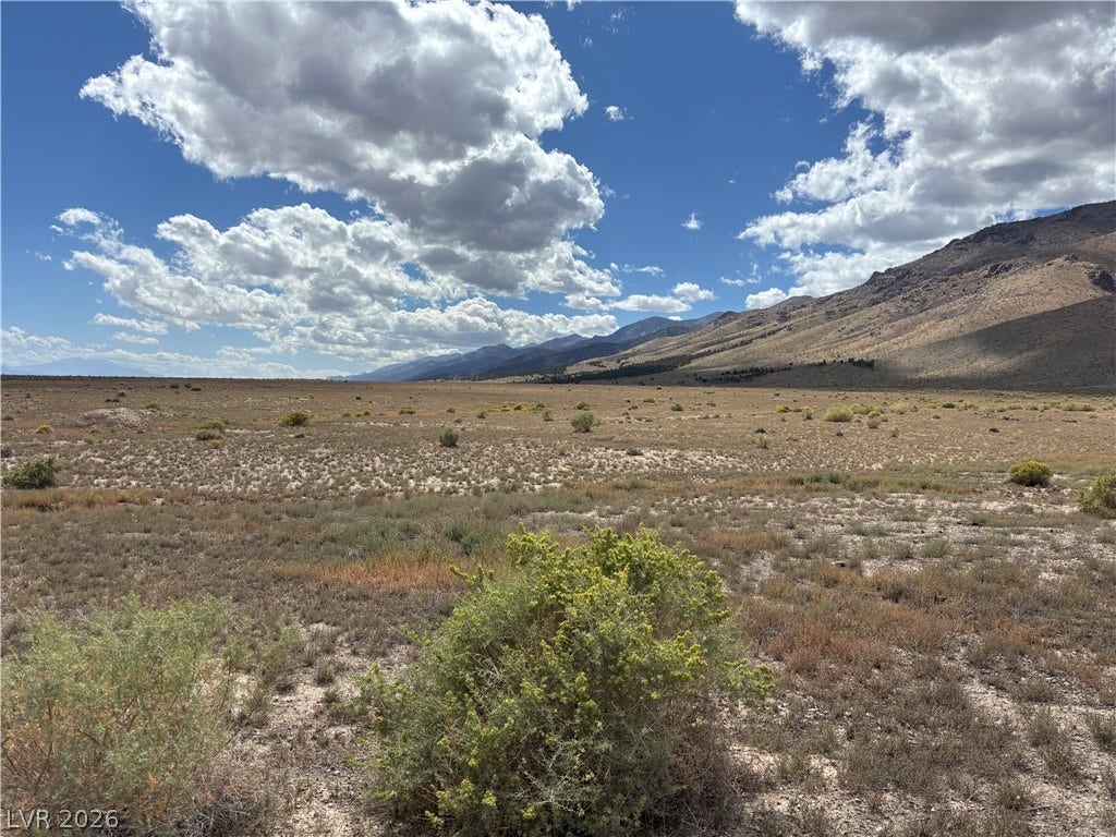 WP Co. WP Co. Road 31 (N. Spring Valley Rd), Ely, NV 89301 Rugged mountains frame the vast open desert landscape under a dynamic sky.
