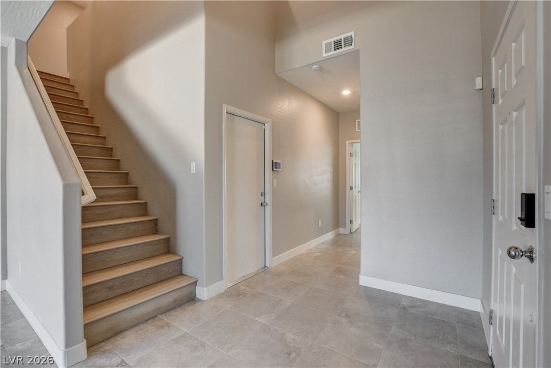 An inviting entryway welcomes guests with clean tile flooring and a neutral color scheme.