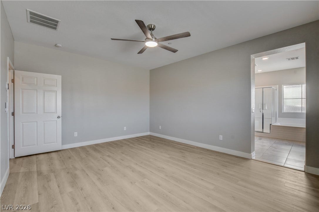 An open doorway connects the main bedroom suite directly to its private bathroom.