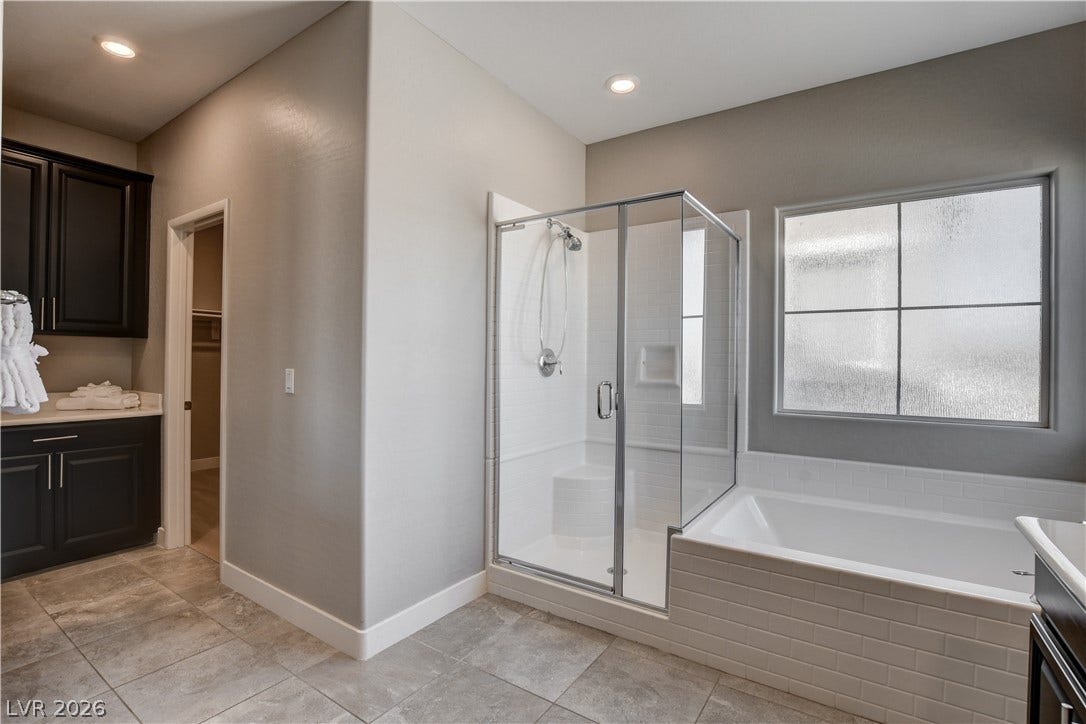 A glass-enclosed shower stands alongside a deep soaking tub in this modern bathroom.