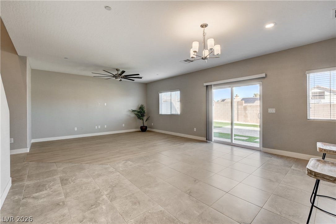An open floorplan seamlessly blends tile and wood-style flooring beneath recessed lighting.