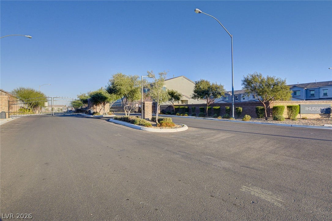 A secure gated entrance welcomes residents with clean paved streets and manicured landscaping.