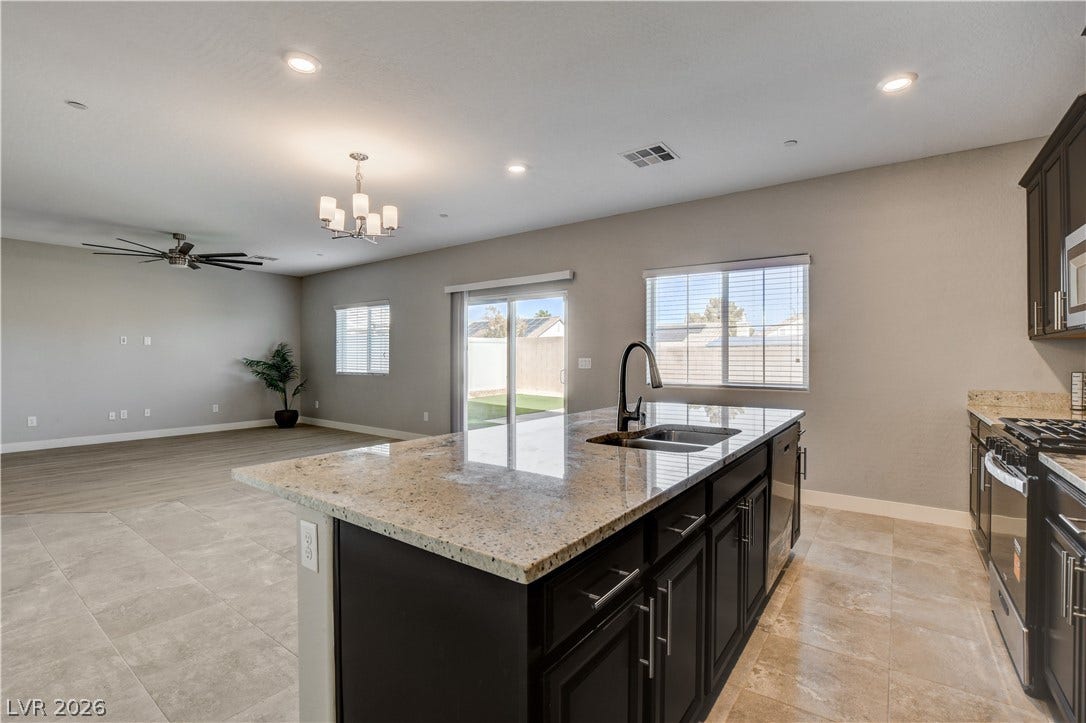 A spacious kitchen features a large granite island and flows into the open living area.