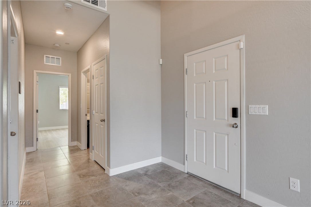 An inviting entryway features durable tile flooring and leads into a bright hallway.
