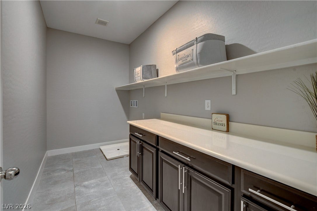 A spacious folding counter and open shelving maximize storage in this functional utility space.