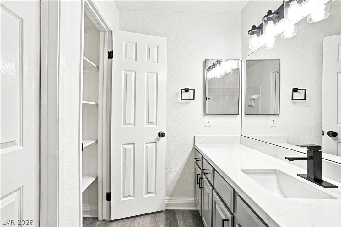 6800 Lake Mead, #2117, Las Vegas, NV 89156 Modern stone countertops and sleek cabinetry elevate this updated bathroom space.