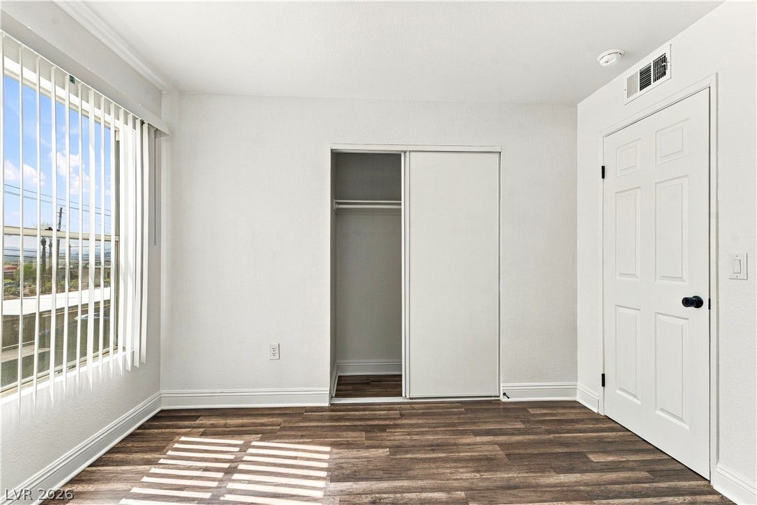 6800 Lake Mead, #2117, Las Vegas, NV 89156 Rich wood-look flooring and crisp white trim enhance this inviting secondary bedroom.