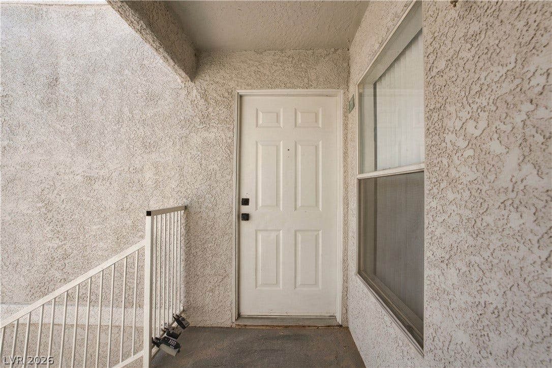 6800 Lake Mead, #2117, Las Vegas, NV 89156 Textured stucco walls surround a classic six-panel entry door on a private covered landing.