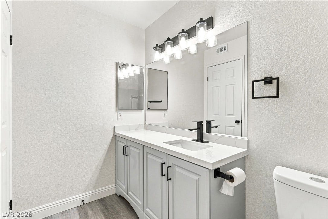 6800 Lake Mead, #2117, Las Vegas, NV 89156 An updated vanity with a stone countertop and modern black fixtures anchors this clean bathroom.