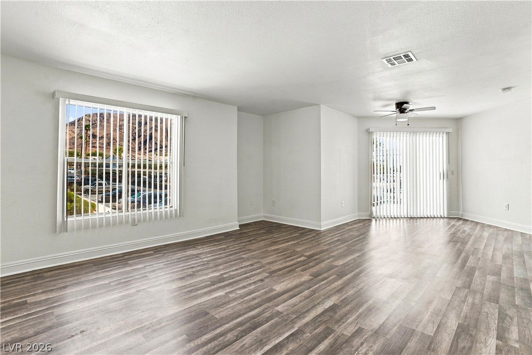 6800 Lake Mead, #2117, Las Vegas, NV 89156 Gleaming wood-look floors complement the light-filled living area featuring a sliding glass door.