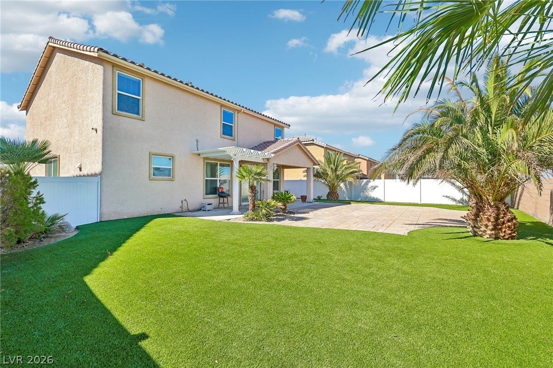 4024 Solar System Street, North Las Vegas, NV 89032 A spacious backyard showcases manicured turf alongside a wide paved patio area.