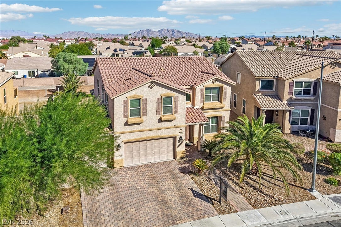 4024 Solar System Street, North Las Vegas, NV 89032 An inviting tile roof highlights this classic two-story exterior featuring a paver driveway.