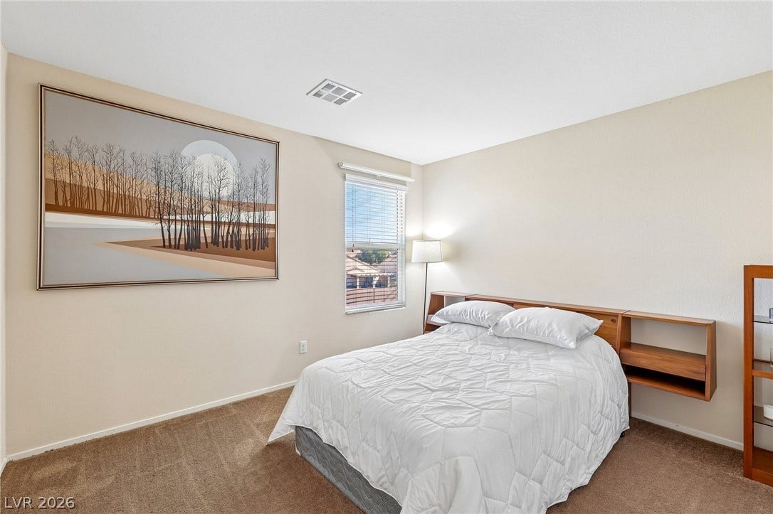 4024 Solar System Street, North Las Vegas, NV 89032 A quiet bedroom offers soft carpeting underfoot alongside a window looking out toward the neighborhood.