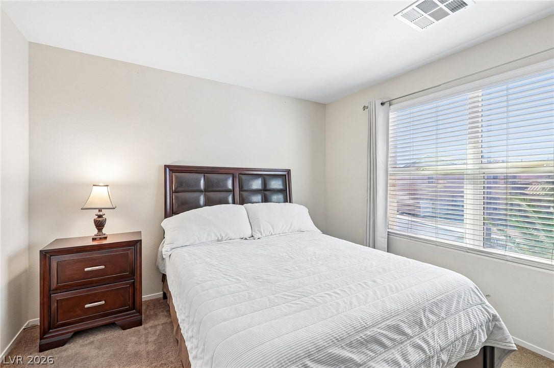 4024 Solar System Street, North Las Vegas, NV 89032 Plentiful natural light filters through a wide window with integrated blinds onto comfortable carpeting.